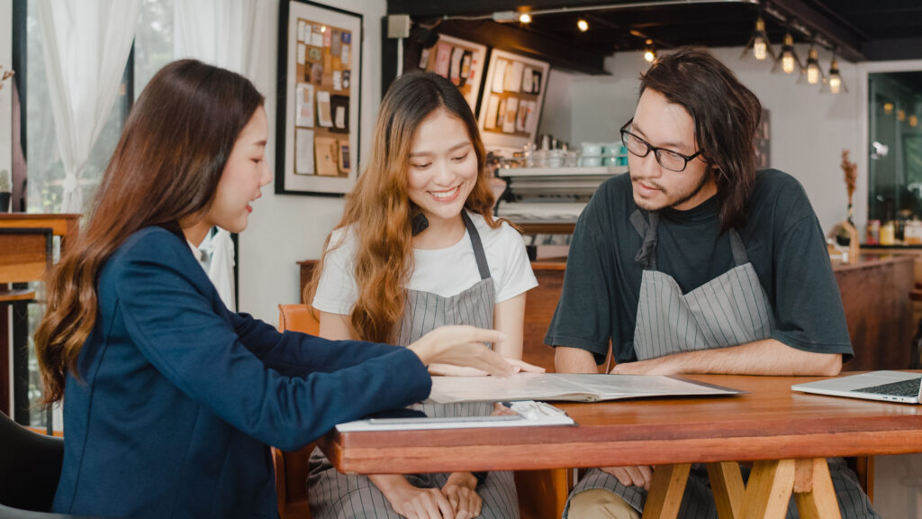 Cheerful Asian small business owners couple meeting with consult